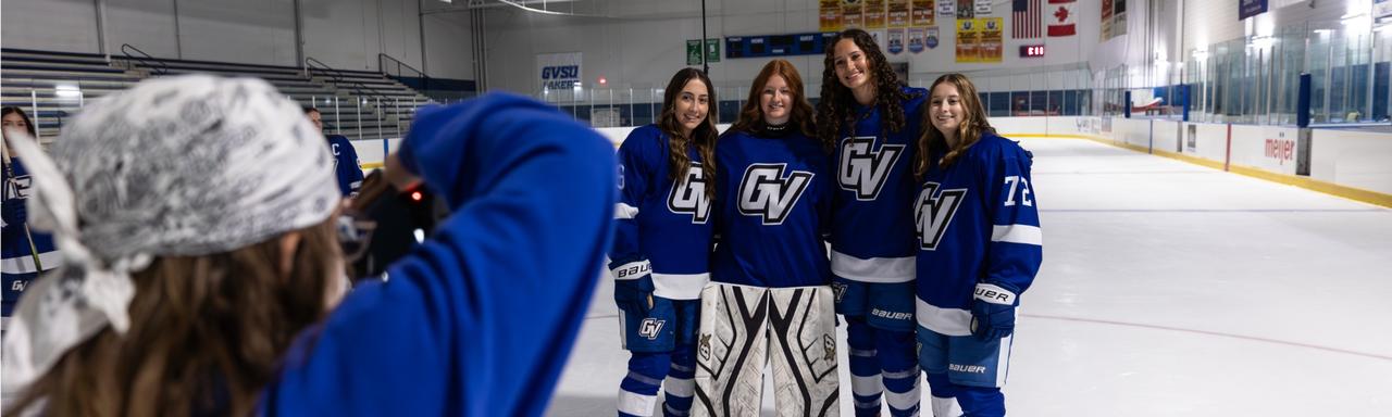 A student photographer taking photos of the women's hockey team